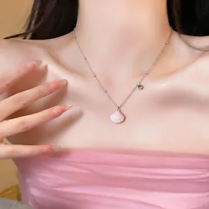 Elegant stainless steel necklace with shell and green zircon on a female model