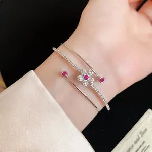 Vue détaillée d'un bracelet jonc double couche en argent avec fleur en zircon au poignet