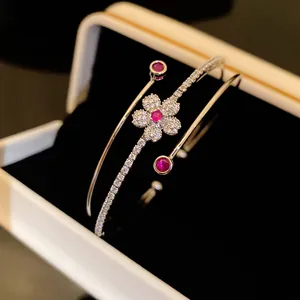 Détail d'un bracelet jonc à double couche orné d'un motif de fleur en zircon rouge