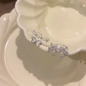 Detail of bowknot pearl and zirconia ring set on a decorative cream ceramic plate