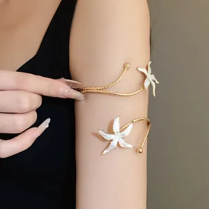 Bracelet de bras élégant étoile de mer dorée avec de délicats détails en émail blanc