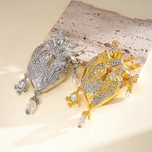 Close-up detail of silver and gold anatomical heart brooches featuring rhinestones and pearls.