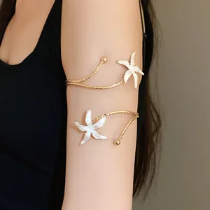 Vue détaillée d'un élégant bracelet de bras étoile de mer en métal doré et émail