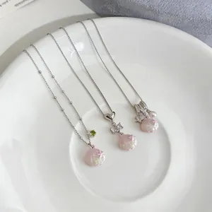 Detail of stainless steel necklaces featuring pink oil-drop shell charms and bow details