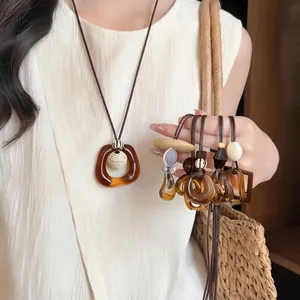 Detail of amber geometric resin pendant necklaces in retro Meillard style