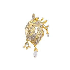 Elegant gold anatomical heart brooch adorned with sparkling rhinestones and pearls.