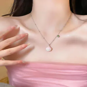 Detailed view of silver stainless steel necklace with pink shell pendant and green zircon