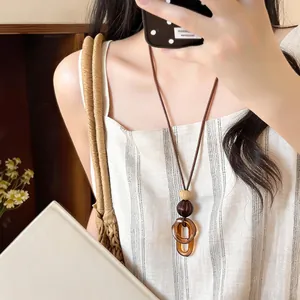 Close-up of retro amber resin geometric pendant necklace on a model wearing white.