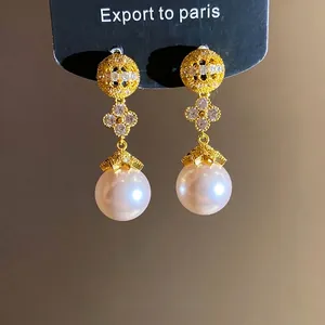 Elegant 18k gold plated earrings featuring zircon flower motifs and round white pearls