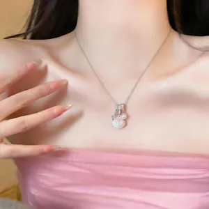 Detail shot of stainless steel necklace with pink shell charm and pearl on neck