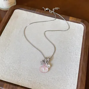Detailed view of silver stainless steel necklace with pink shell and star pendant