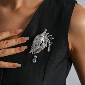 Detailed shot of a silver anatomical heart brooch with crystals and pearls on a black dress
