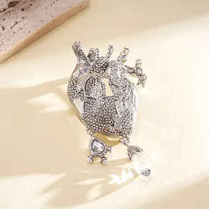 Close-up of anatomical heart brooch with sparkling rhinestones and crystal drop detail