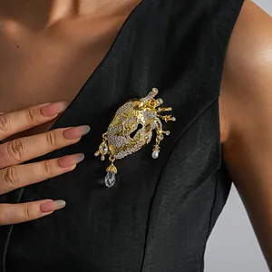 Detail shot of an anatomical heart brooch with rhinestones and pearls on a black vest