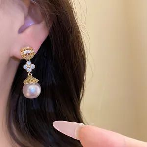 Detail view of flower pearl drop earrings with zircon in 18k gold plated finish