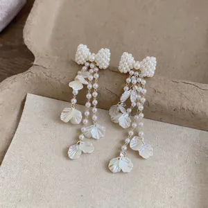 Elegante Perlenohrringe mit Schleife und zarten weißen Blütenblattanhängern