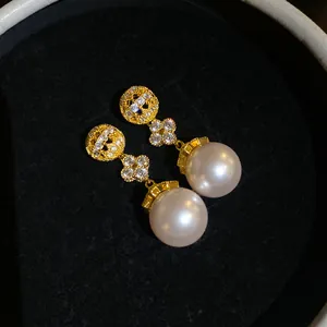 Detailed view of 18k gold-plated zircon flower earrings with large pearls