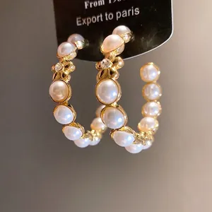 Créoles élégantes en forme de C dorées avec perles synthétiques et accents de fleurs en cristal