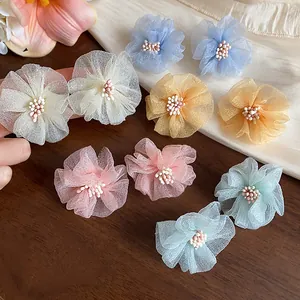 Dettaglio di orecchini a lobo a fiore in chiffon colorato con elegante trama a petali