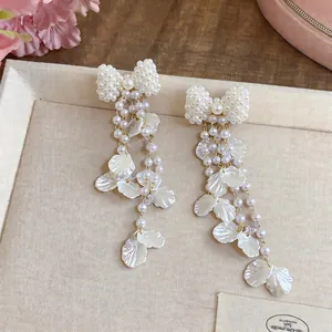 Elegante Perlen-Schleifen-Ohrringe mit Muschel-Blüten-Quasten und Silbernadeln.