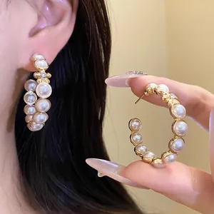 Vue détaillée de boucles d'oreilles créoles en C avec perles et fleurs en strass
