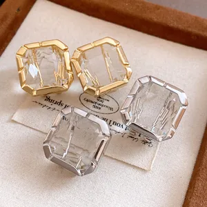 Detailed close-up of square faceted crystal earrings in gold and silver finishes for women