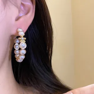 Vue détaillée de boucles d'oreilles vintage en forme de C avec perles et fleurs