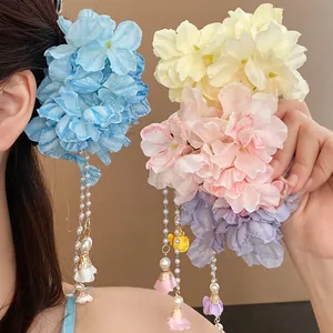 Close-up of bohemian fabric flower hair clips with elegant pearl tassel charms