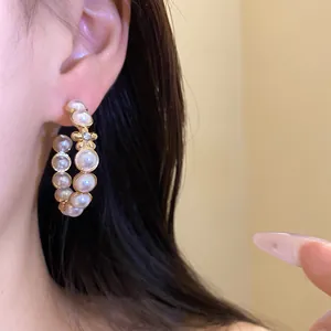 Gros plan détaillé de boucles d'oreilles créoles vintage en C avec perles et fleur