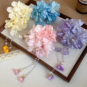 Detailed shot of handmade fabric flower hair clips with bead tassels in a tray