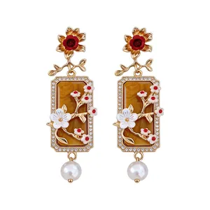 Eleganti orecchini vintage con fiori, perle rettangolari e strass luccicanti.