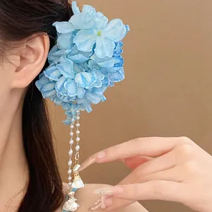 Elegant close-up view of a blue fabric flower hair clip with pearl tassels on hair