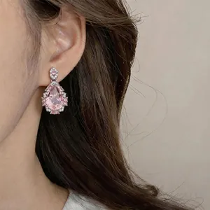 Eleganti orecchini a goccia in zircone rosa indossati da una modella per un look di lusso.