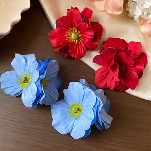 Barrettes à fleurs en tissu rouge et bleu posées élégamment sur un support en bois sombre
