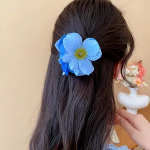 Vue de dos d'une femme portant une pince à cheveux réaliste en fleur de tissu bleu