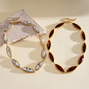 Detailed view of gold-tone marquise-cut stone necklaces in clear and amber