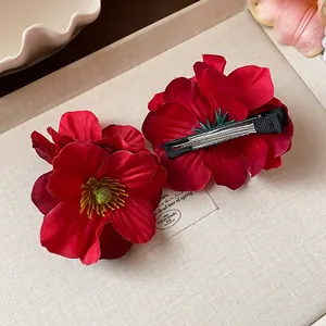 Vue détaillée montrant l'avant et l'arrière des pinces à cheveux fleurs rouges
