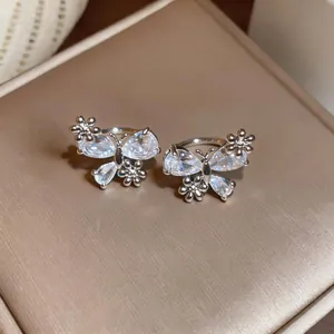 Exquisite butterfly and flower ear clips with zircon stones in a silver finish.