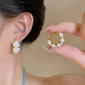 Detaillierte Ansicht der 18K vergoldeten Maiglöckchen-Creolen mit weißen Perlen.