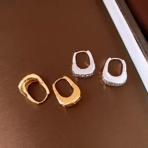 Dettaglio di orecchini a cerchio a U placcati oro 18K con design a trama increspata