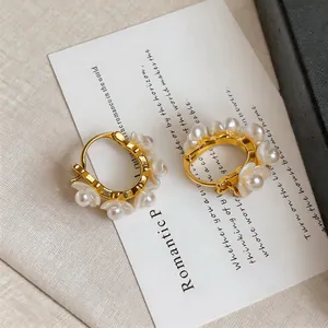 Nahaufnahme von 18 Karat vergoldeten Maiglöckchen-Ohrringen mit eleganten weißen Perlen
