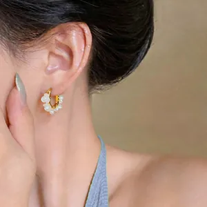 Detailaufnahme der 18K vergoldeten Creolen mit Maiglöckchenblüten und Perlen für Damen