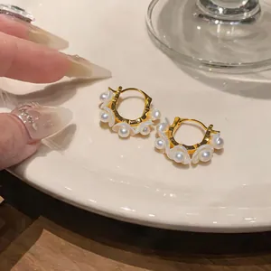 Detailaufnahme von mit 18 Karat Gold plattierten Maiglöckchen-Ohrringen mit eleganten Perlen.