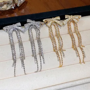 Luxury 18k gold plated zircon bow knot tassel earrings displayed on a beige velvet tray