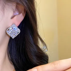 Gros plan détaillé de boucles d'oreilles carrées en zircon vintage portées par un modèle