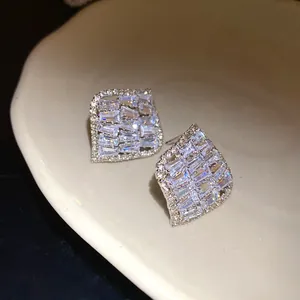 Boucles d'oreilles carrées vintage avec zircons pavés dans une coupelle en céramique.