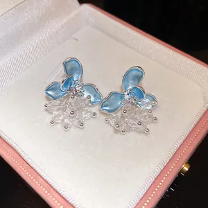 Detail view of light blue enamel flower earrings with clear crystal beads in a pink gift box.