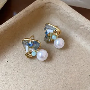 Detail shot of elegant geometric pearl earrings with crystals and gold-plated finish