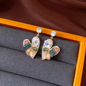Detailed macro view of vintage ethnic style earrings with colorful crystal beads and pearls