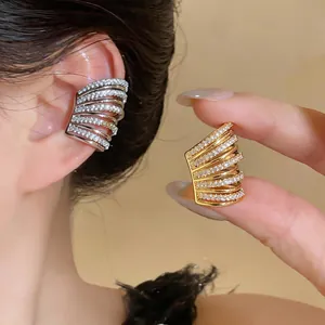 Dettaglio ravvicinato di ear cuff multistrato in zirconi con finitura in oro e argento